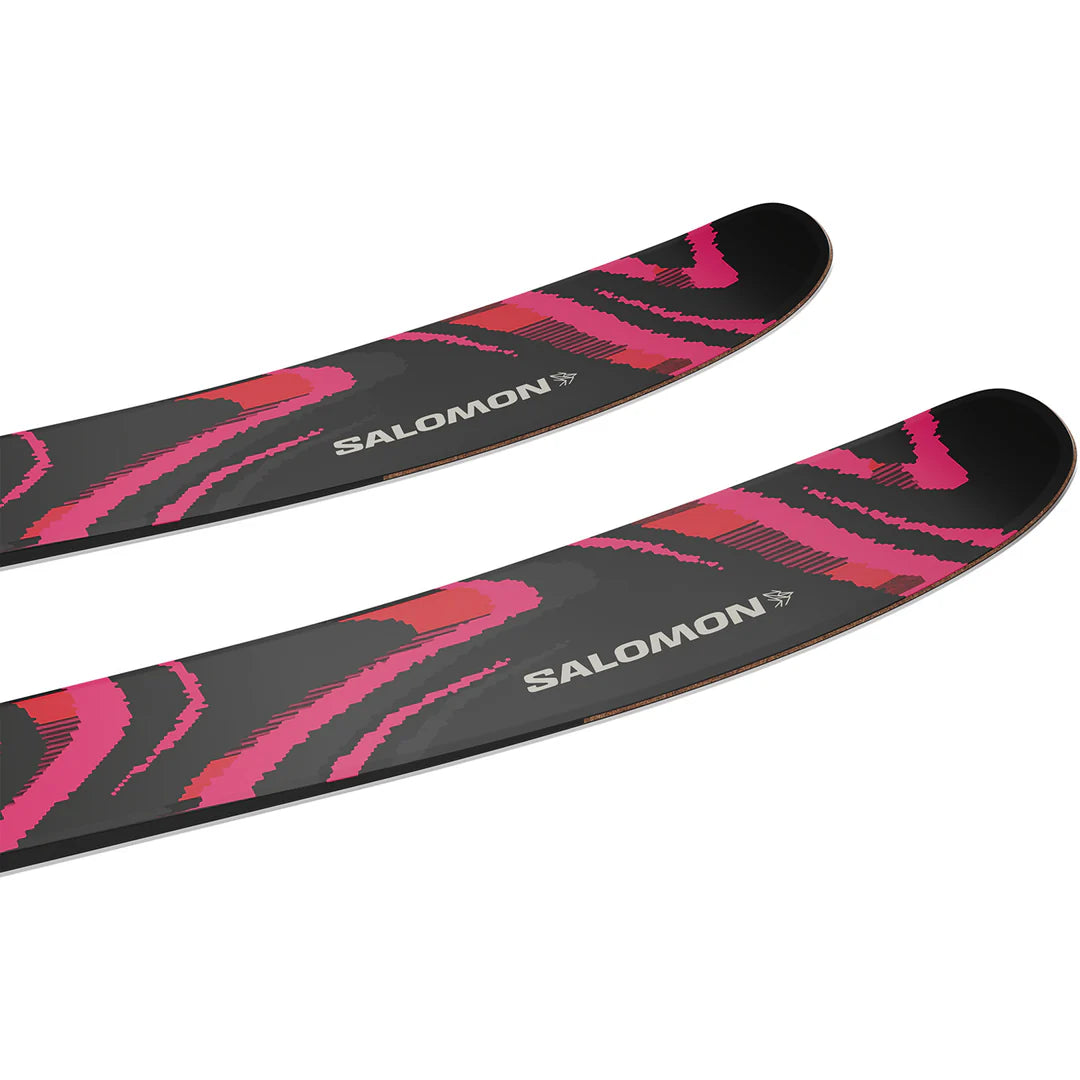Two skis with pink and black design on a white background, featuring the Salomon brand.